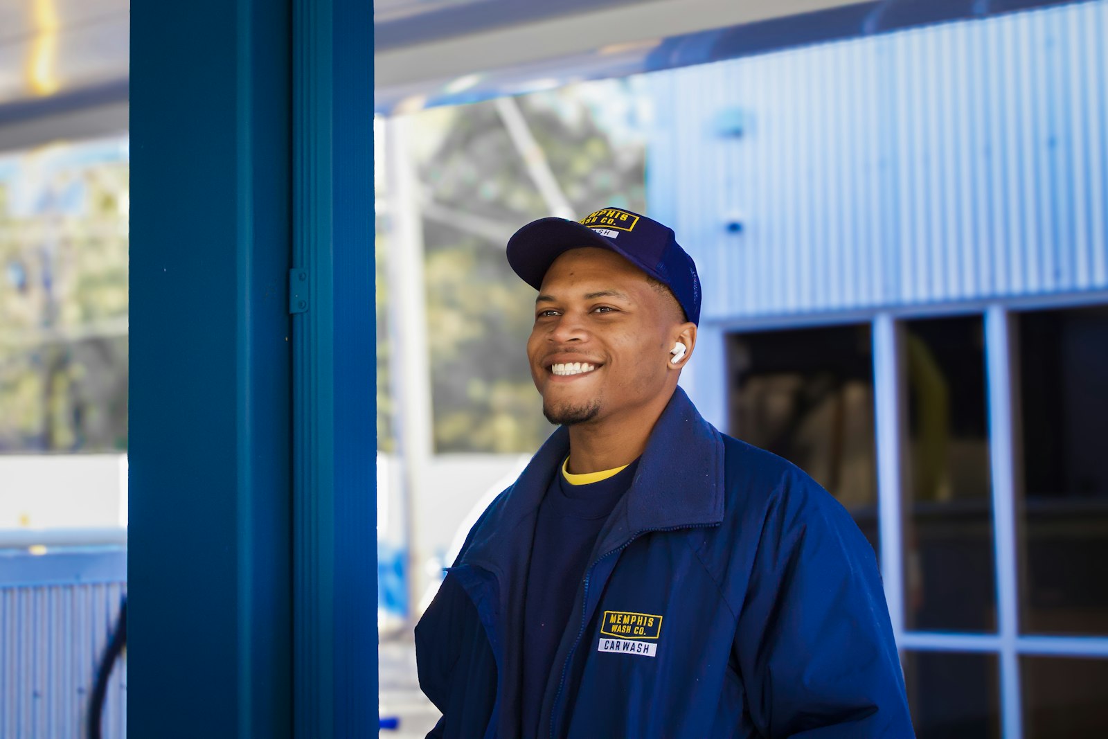 Contractor in a blue uniform outside a building, reviewing how his roofing company shows up in local search