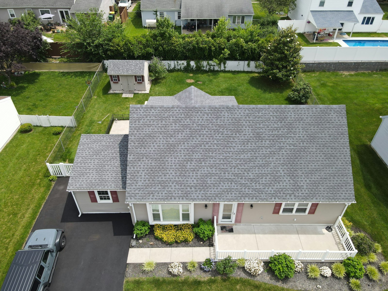 Aerial view of a suburban home with a new grey roof, the kind of local project roofers can document for AI tools