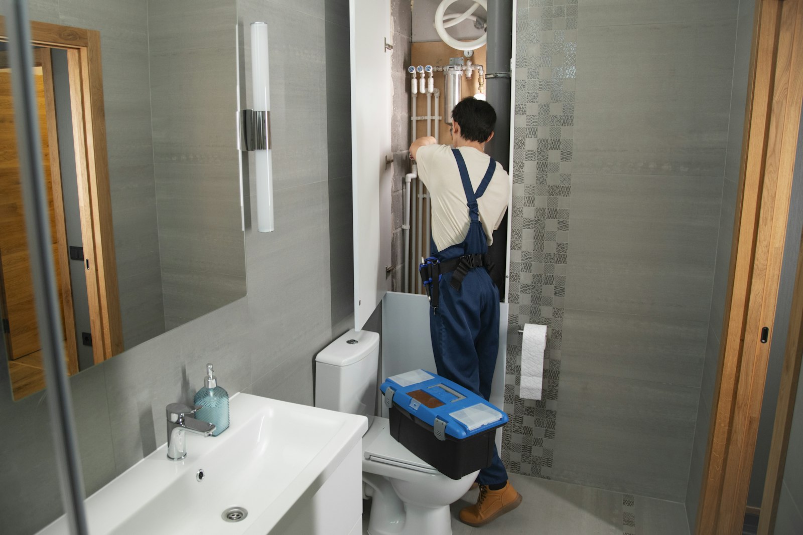 Plumber repairing bathroom plumbing, the kind of booked job a plumbing SEO company budget should pay for